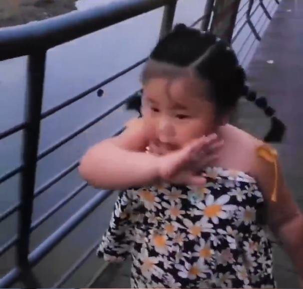 Cô bé vừa lau mồ hôi trên mặt, vừa nói yêu bố. Ảnh cắt từ clip. Cô bé vừa lau mồ hôi trên mặt, vừa nói yêu bố. Ảnh cắt từ clip.