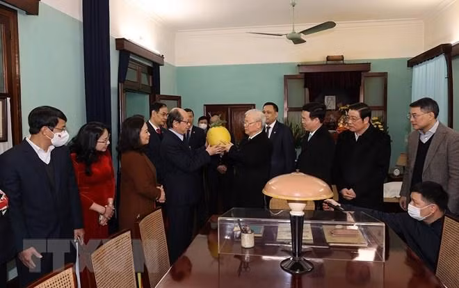Cán bộ, nhân viên Khu di tích Chủ tịch Hồ Chí Minh trao tặng Tổng Bí thư Nguyễn Phú Trọng quả bòng từ vườn Bác. (Ảnh: Trí Dũng/TTXVN)