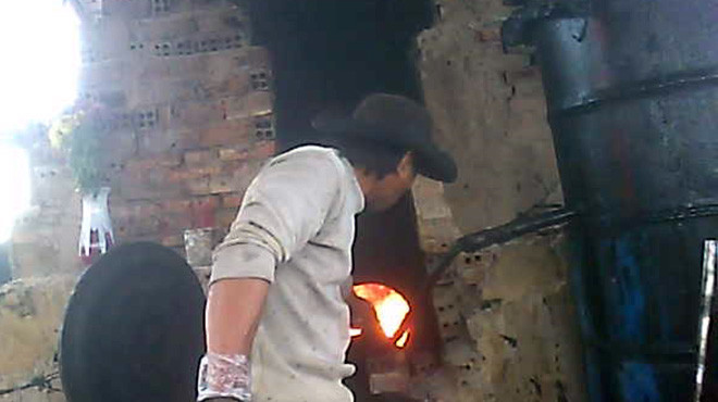 Thợ nấu dầu tại cơ sở của ông Hùng. Ảnh: Tuổi Trẻ