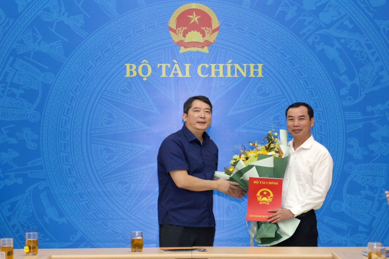 Thứ trưởng Bộ Tài chính Cao Anh Tuấn trao quyết định và tặng hoa cho ông Ngô Chí Tùng. Ảnh: Đức Minh Thứ trưởng Bộ Tài chính Cao Anh Tuấn trao quyết định và tặng hoa cho ông Ngô Chí Tùng. Ảnh: Đức Minh