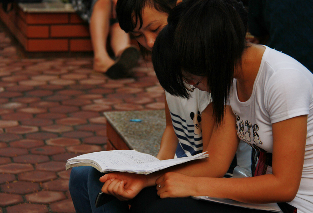 Hai thí sinh cùng đọc chung một tập tài liệu. Ảnh: Trường Phong