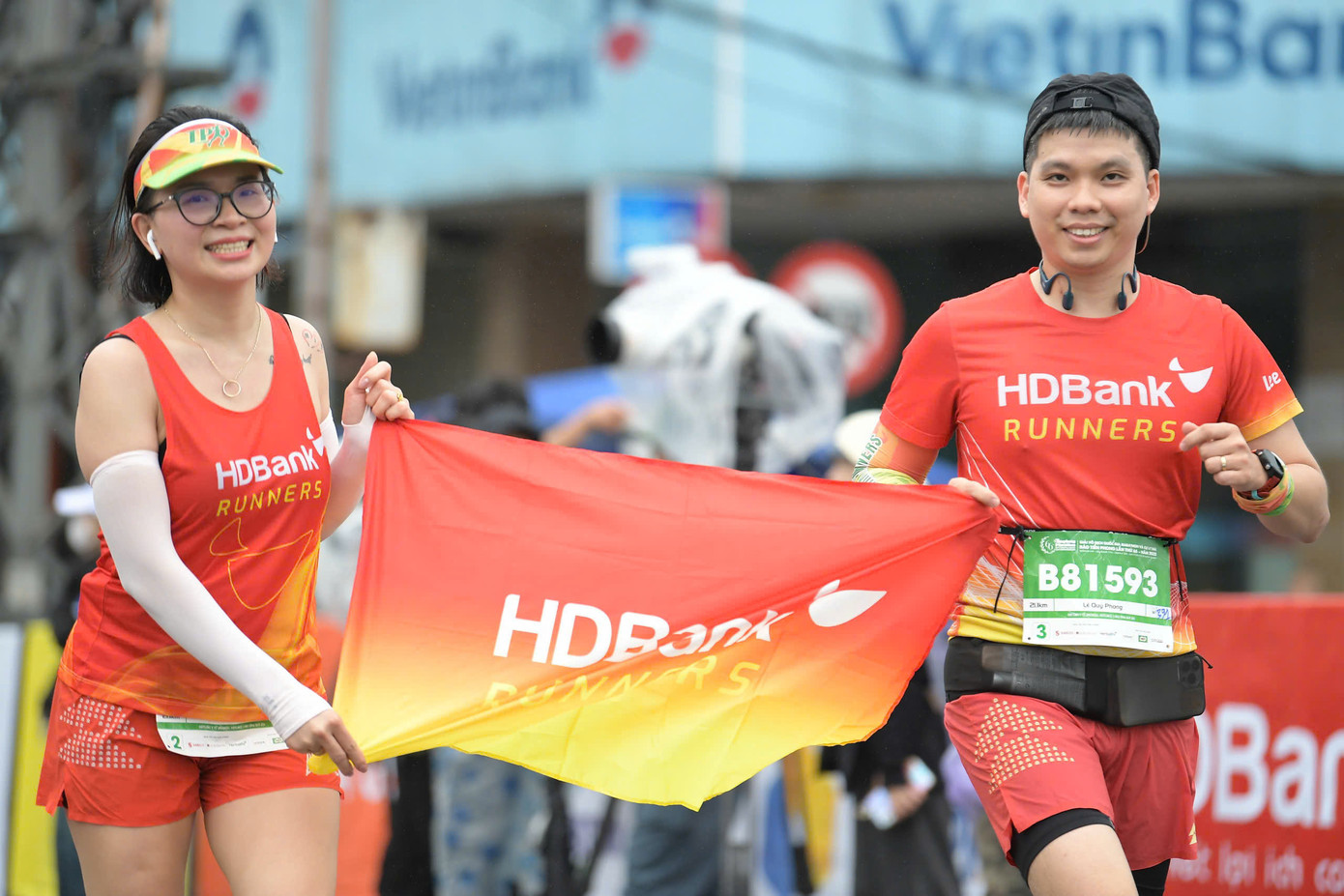 Cặp đôi trong Câu lạc bộ HDBank Runners mang theo cờ thương hiệu trong suốt chặng đua. Được biết, anh Lê Quý Phong - Văn Phòng Đại Diện khu vực phía Bắc, cùng vợ là Trần Thị Hiên thường xuyên tham gia các giải chạy.