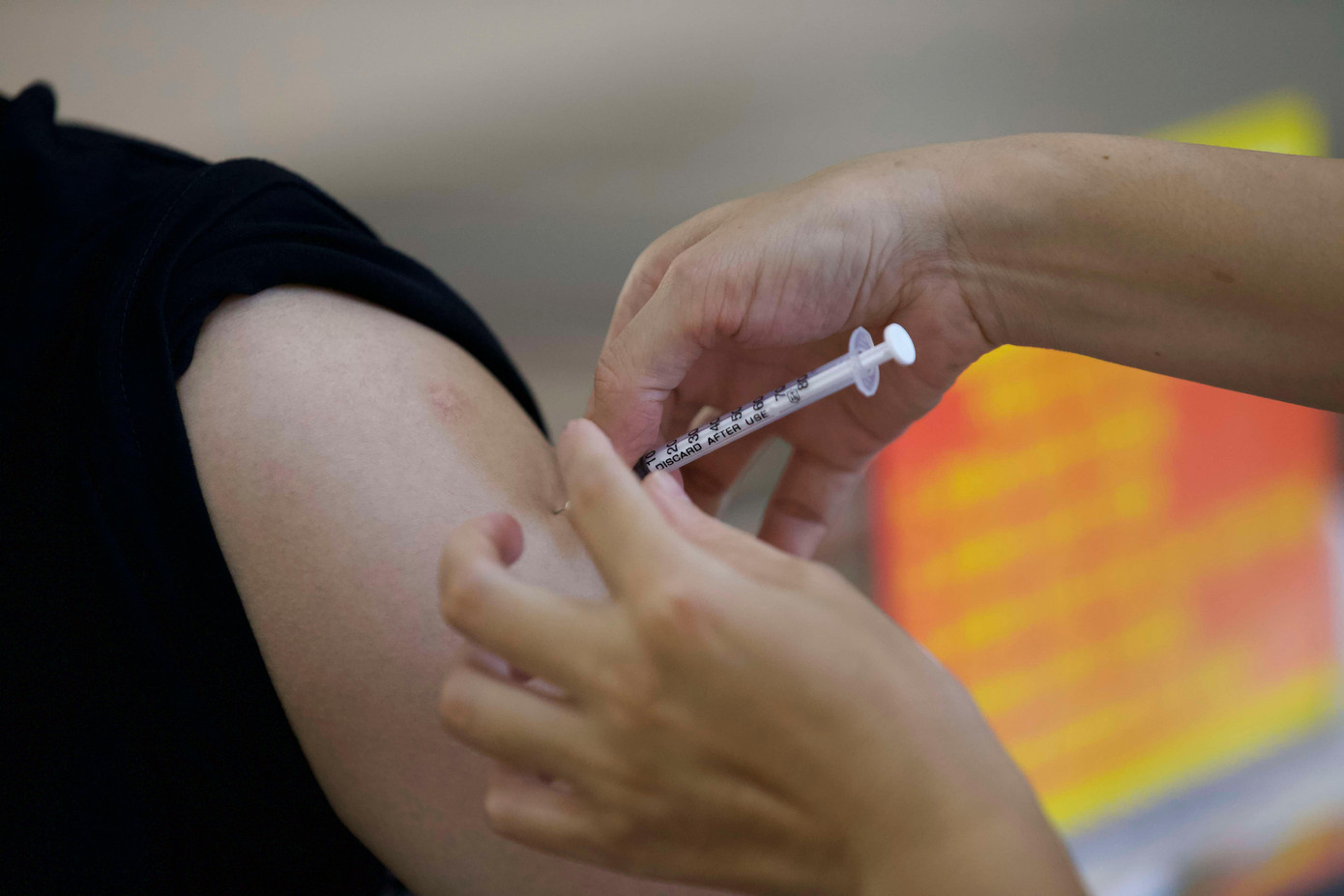 Nhân viên y tế tiêm vắc xin cho người dân sau khi sàng lọc xét nghiệm COVID-19.