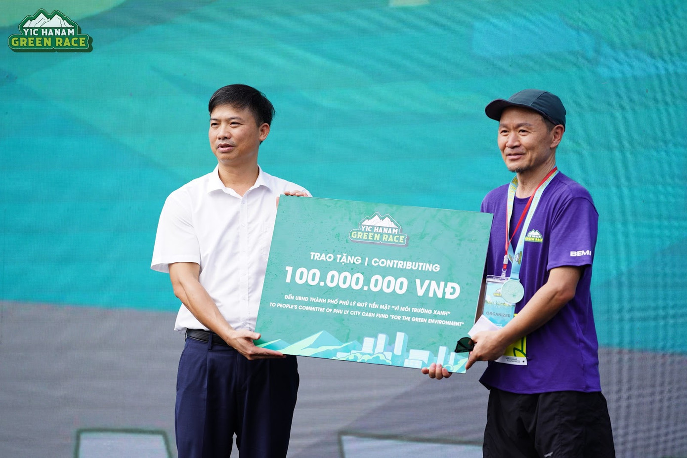 Chủ tịch công ty YIC trao 100.000.000 VNĐ cho UBND thành phố Phủ Lý (Ảnh: YIC Hanam Green Race)