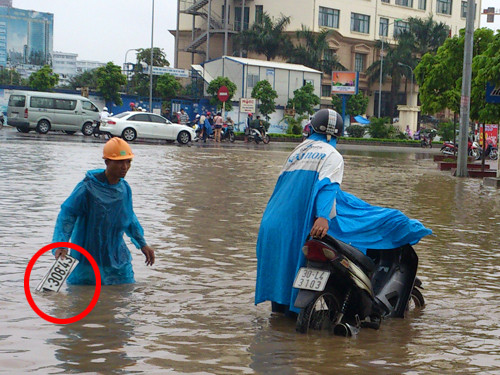 Người dân bì bõm lội nước, nhặt biển số ô tô phía sau tòa nhà Keangnam