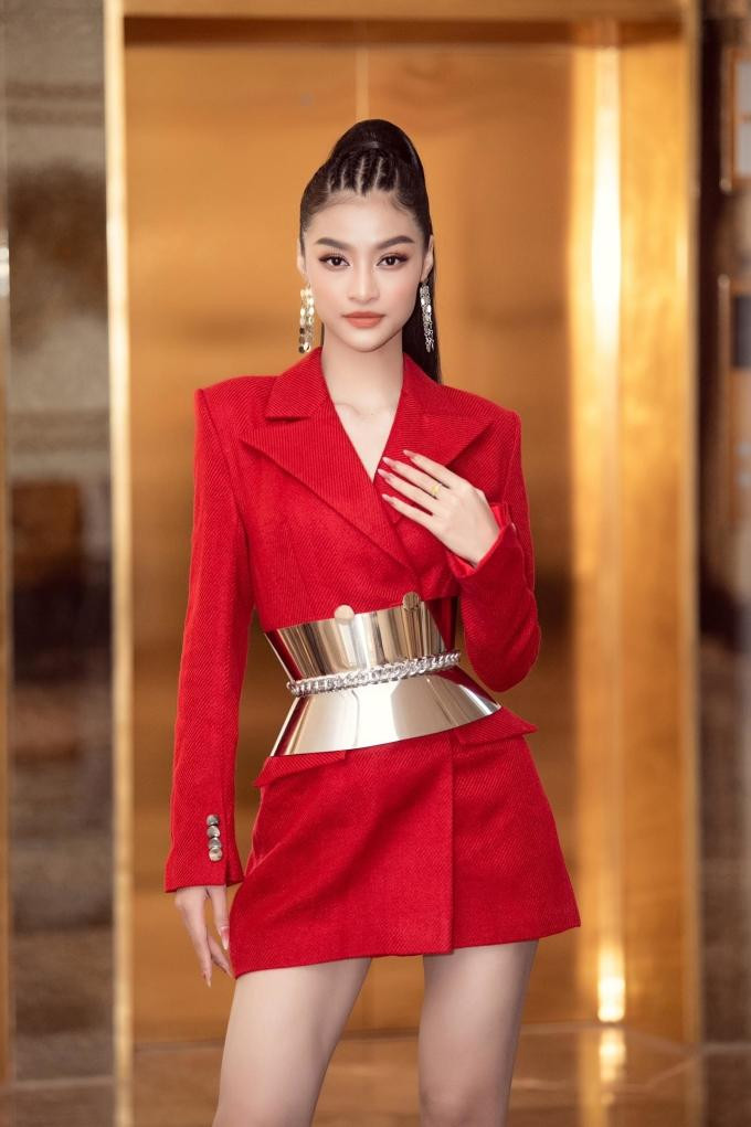 Á hậu Kiều Loan diện váy đỏ rực, kết hợp chi tiết đai lưng kim loại đầy cá tính.