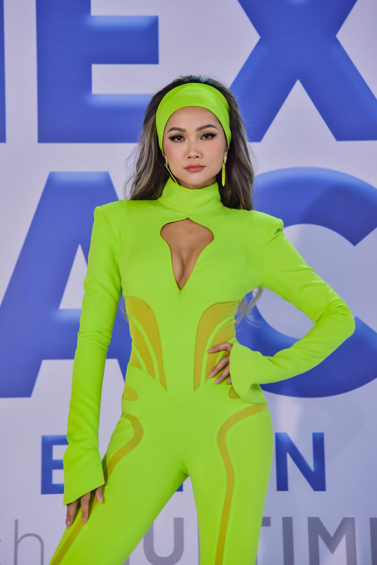 Gam màu xanh neon tiếp tục được H'Hen Niê lăng xê. Thiết kế kiểu jumpsuit với đường xẻ vòng một táo bạo mang lại vẻ cá tính, quyến rũ cho người đẹp Ê Đê.