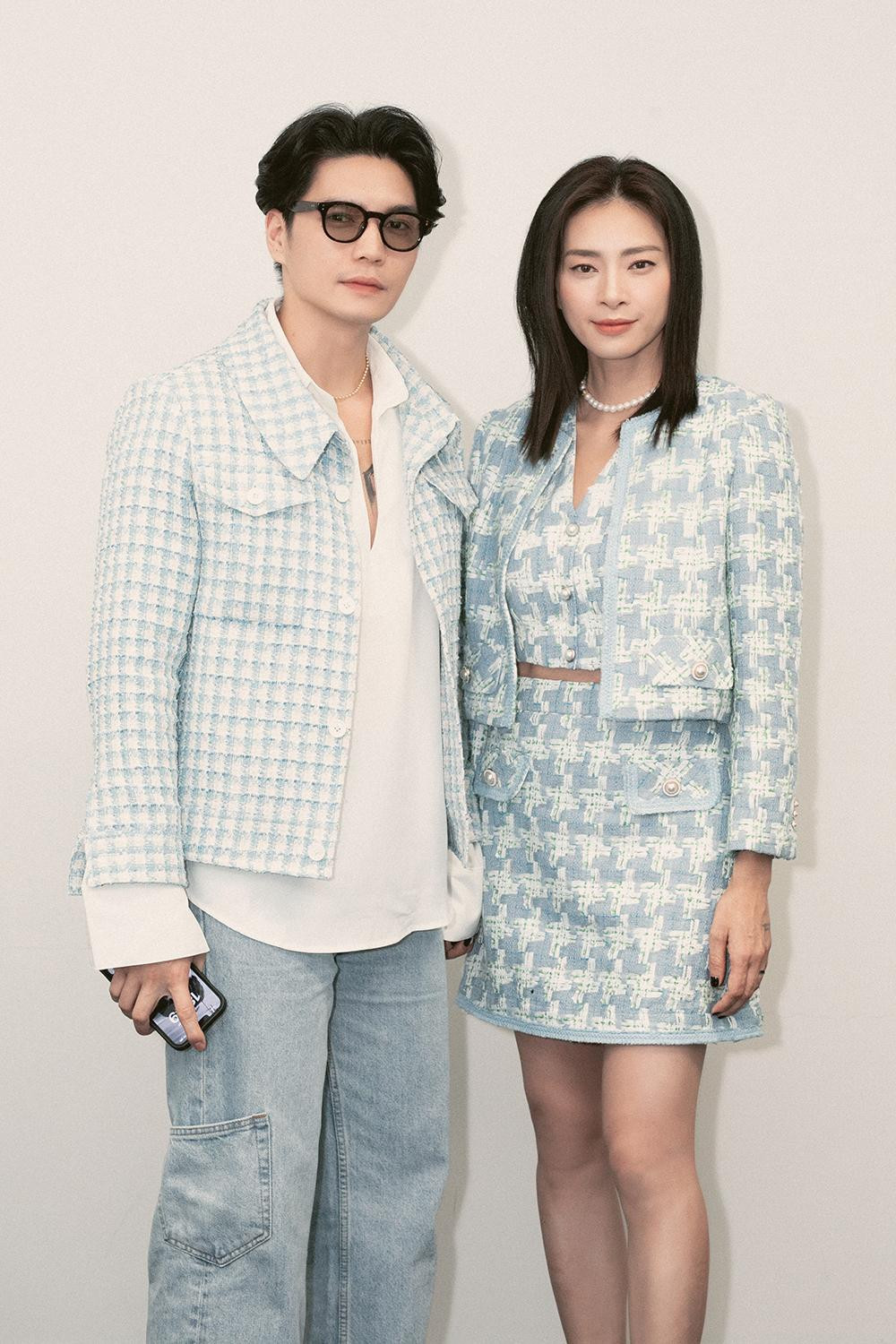 Vợ chồng đạo diễn, diễn viên điện ảnh, nhà sản xuất phim Ngô Thanh Vân - doanh nhân Huy Trần diện trang phục cùng tông màu xanh trẻ trung. Ngô Thanh Vân mang đến hình ảnh thanh lịch với chân váy, phối cùng áo hở eo, kết hợp thêm áo khoác bên ngoài bằng vải tweed. Trong khi đó, doanh nhân Huy Trần phối áo vải tweed dáng sơ mi phom rộng bên ngoài, đi cùng sơ mi trắng bên trong cùng quần dáng rộng cổ điển.