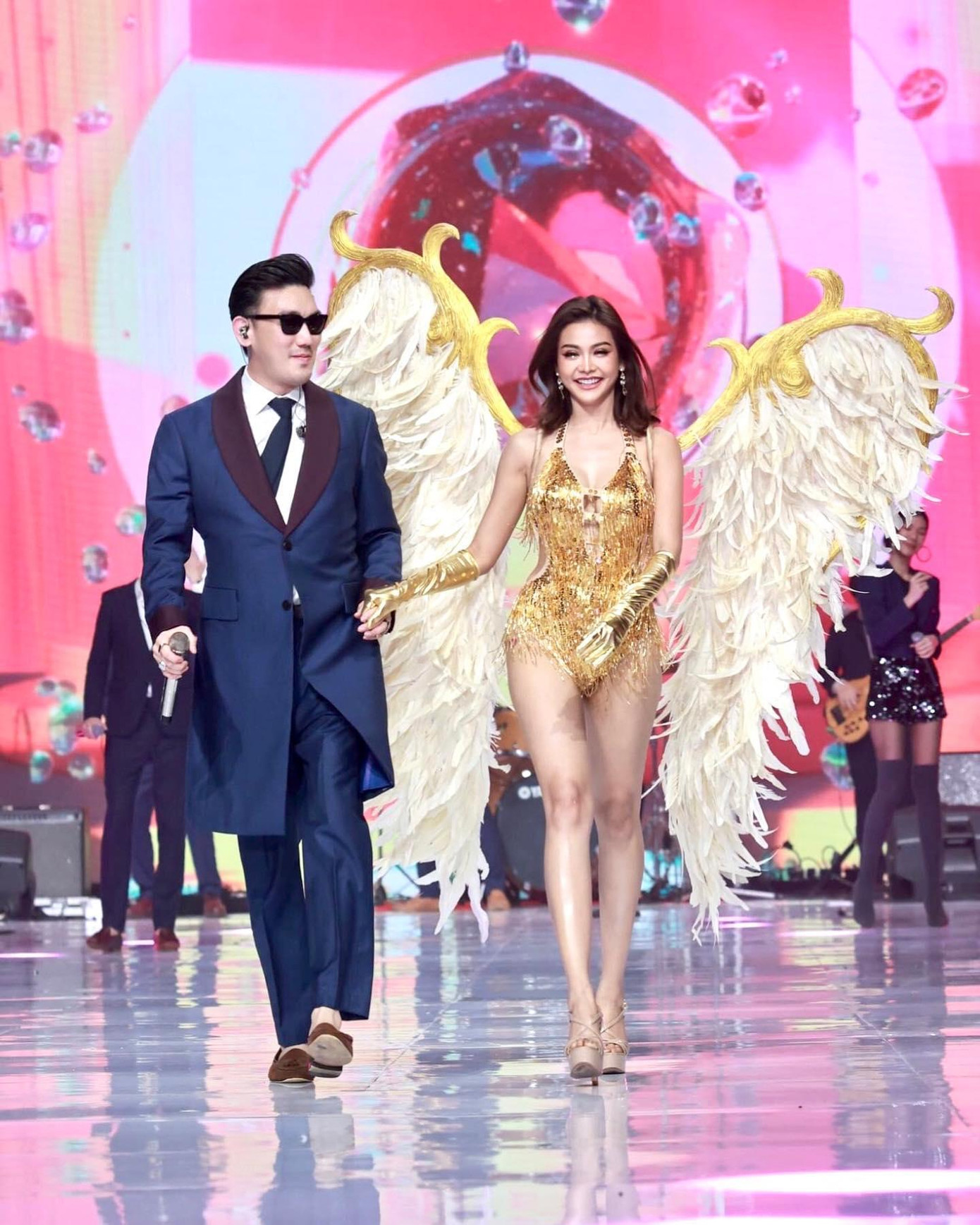 Á hậu 1 người Thái Lan - Engfa Wahara diện bộ áo tắm tua rua cách điệu màu vàng, đeo cánh thiên thần khi sải bước trên sàn diễn, khoe đôi chân quyến rũ.