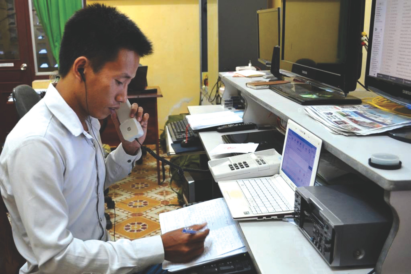 Phóng viên Nguyễn Thành trực điện thoại ghi chép nội dung tường thuật của phóng viên ở Hoàng Sa