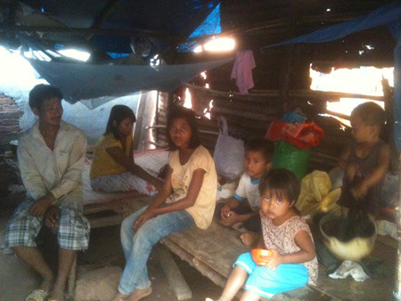 Vợ chồng chị Xuân ngồi trong túp lều của gia đình mình