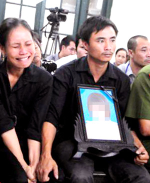 Khi nghe HĐXX con gái lớn bị tổn thương 51% sức khỏe, con gái nhỏ bị chém chết bằng 12 nhát dao mẹ nạn nhân bấu tay vào nhau đau đớn khóc không thành tiếng còn anh H - bố nạn nhân bấu tay vào di ảnh cô con gái mặt đanh lại cố nén đau đớn