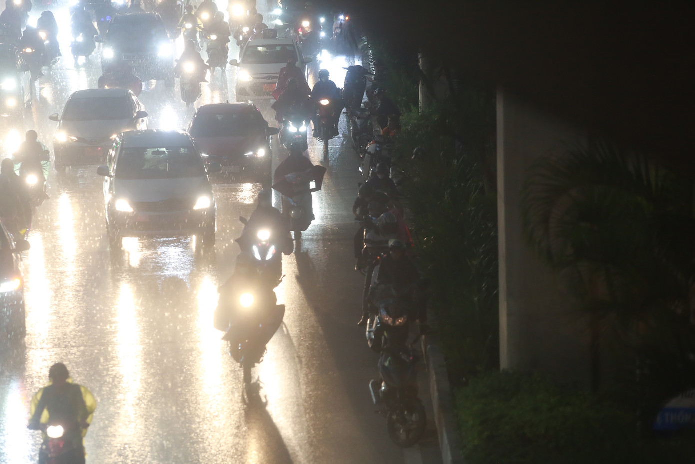 Phương tiện nối đuôi nhau "núp" dưới đường sắt trên cao để tránh mưa.