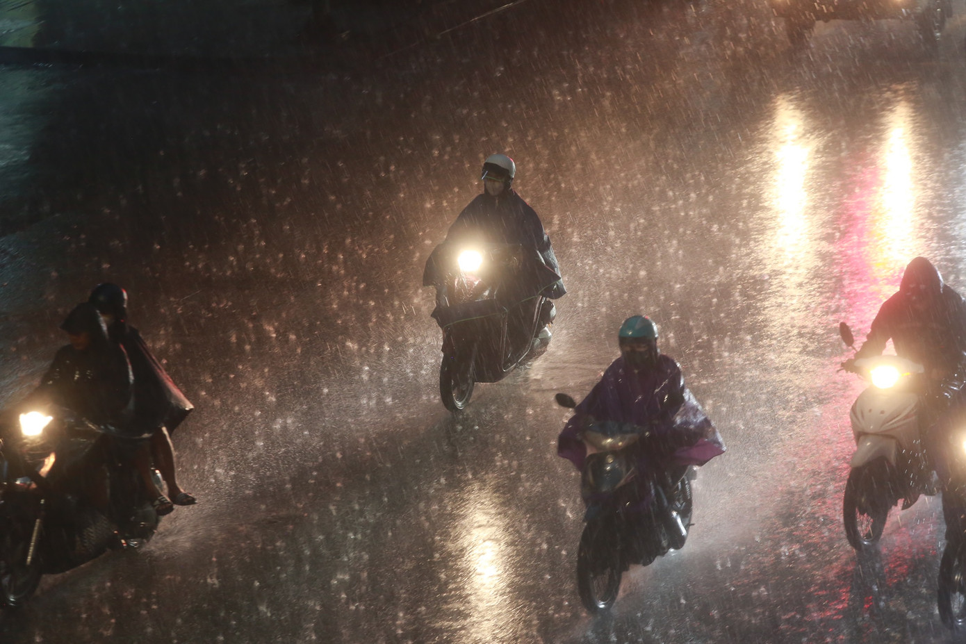 Người dân vội vã về nhà dưới cơn mưa trắng trời.