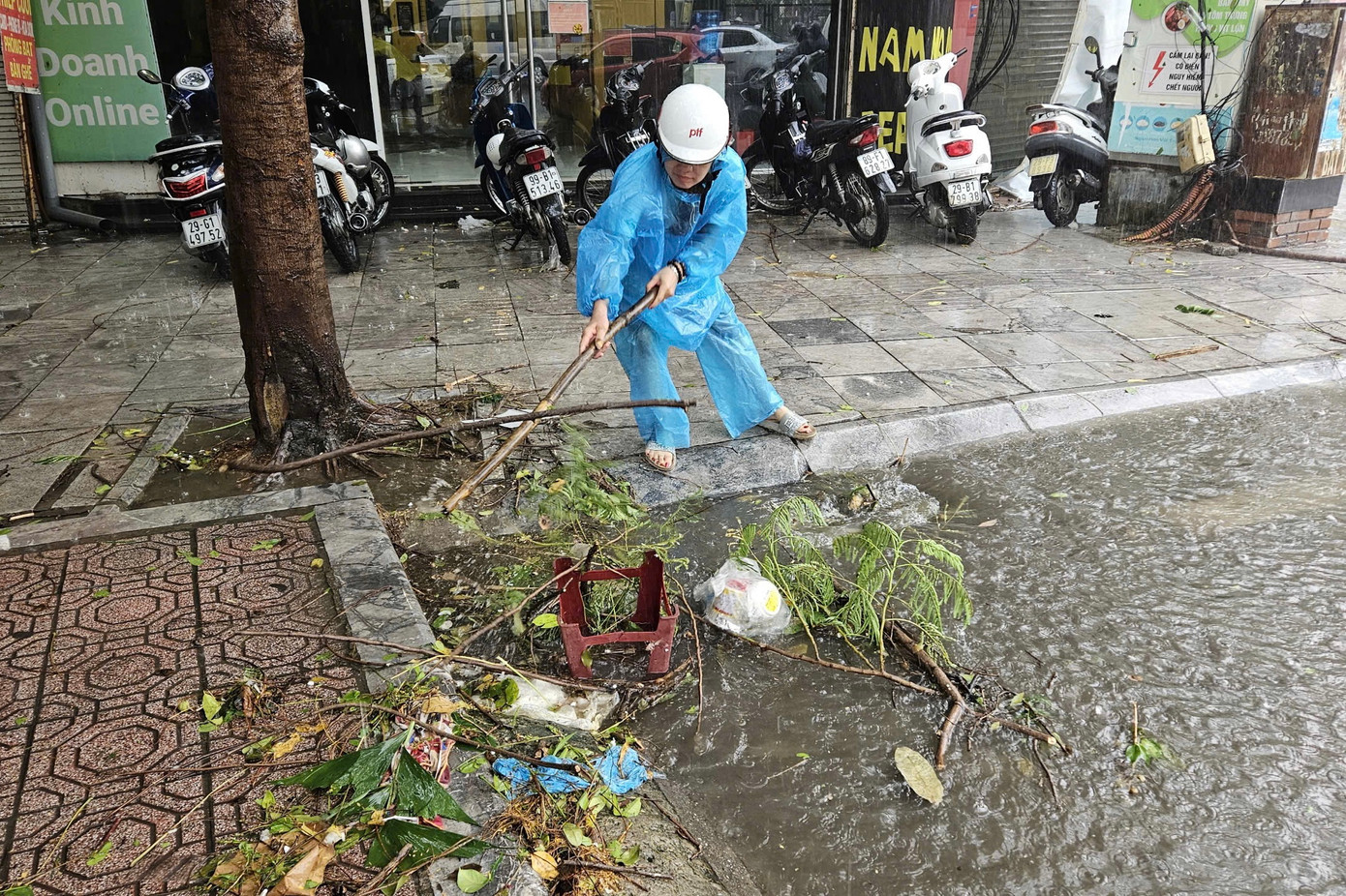 Người dân dọn rác ở miệng cống.