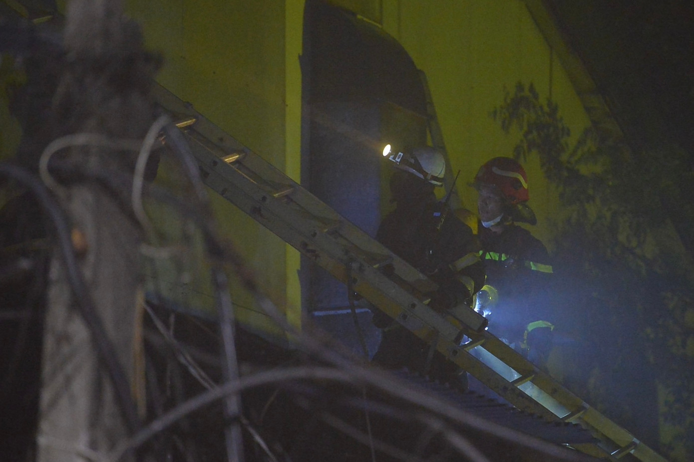 Lực lượng PCCC phải dùng thang, dụng cụ để phá tường, tiếp cận hiện trường.