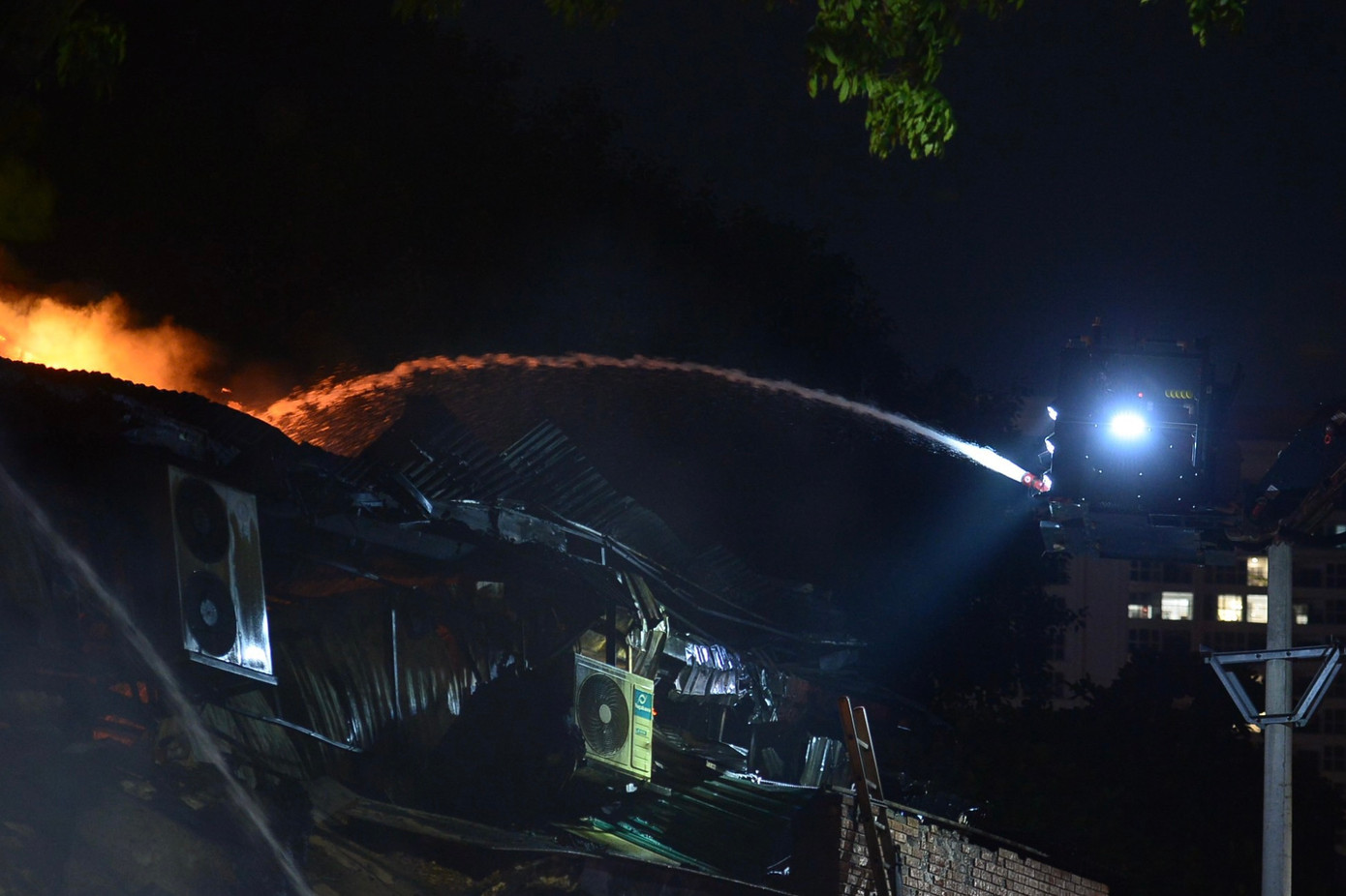 Cảnh sát PCCC dùng xe thang để bắc vòi rồng phun nước vào trung tâm đám cháy.