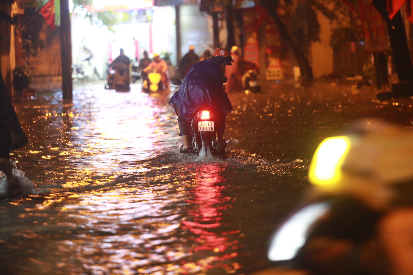 Phố Tô Vĩnh Diện ngập ngang bánh xe, nhiều phương tiện vẫn liều mình lao vào biển nước.