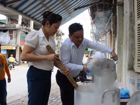 Vợ chồng anh Hòa, chị Hương nấu cháo cho các bệnh nhân nghèo