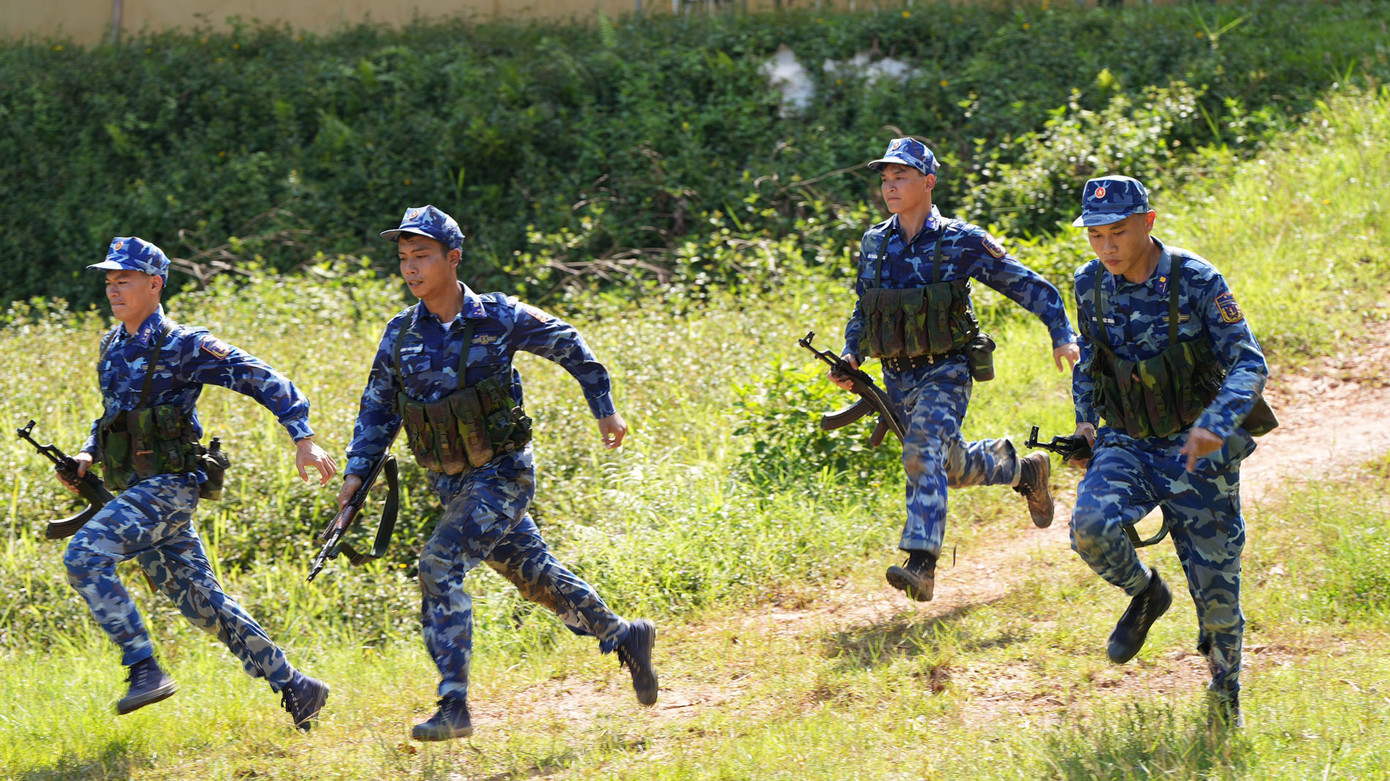 Các tuyển thủ nam vượt qua 100m thực hiện nội dung bài bắn đồng đội vận động bắn mục tiêu kim loại số 1 ban ngày súng Tiểu liên AK.