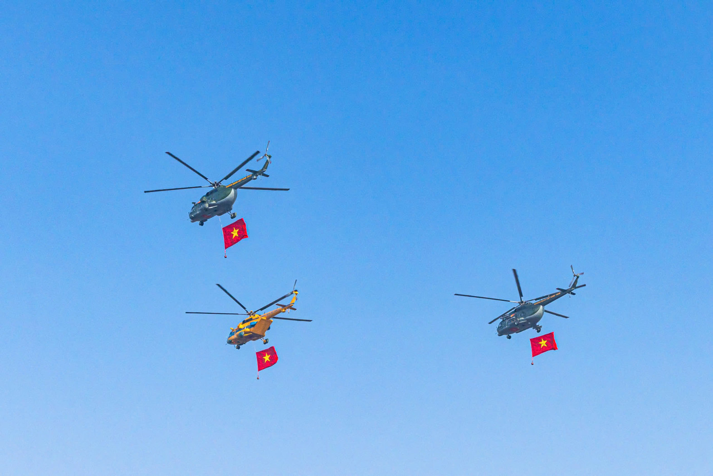 3 chiếc trực thăng vũ trang luyện tập bay treo cờ theo đội hình mũi tên.