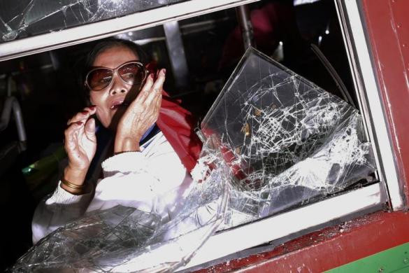 Người phụ nữ sợ hãi trong xe bus khi người biểu tình tấn công vào xe gần sân vận động Bangkok