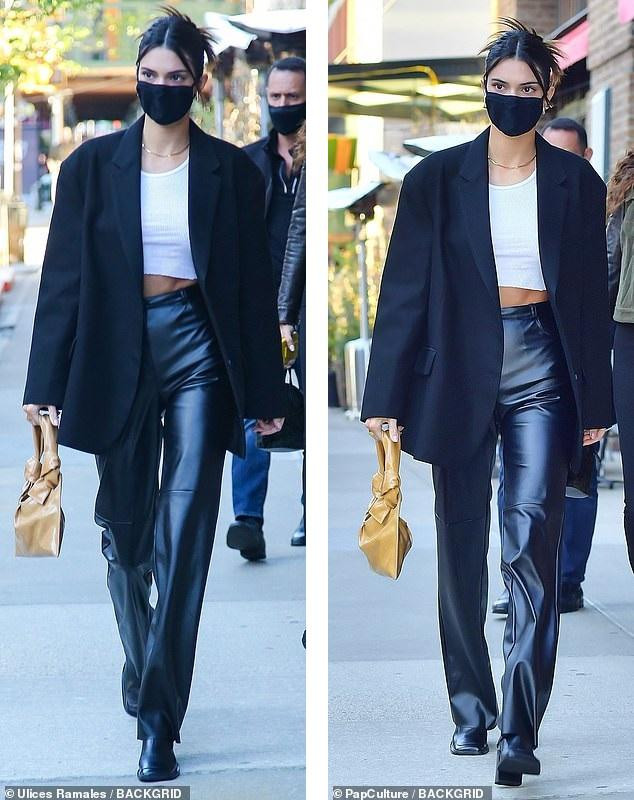 &quot;Chân dài&quot; sinh năm 1995 mặc áo crop-top màu trắng, khoác áo blazer đen, mặc quần da đen và boot thấp cổ. &quot;Điểm nhấn&quot; là chiếc túi xách tay màu nâu nhạt. Cô đeo khẩu trang đen và tóc búi cao gọn gàng.