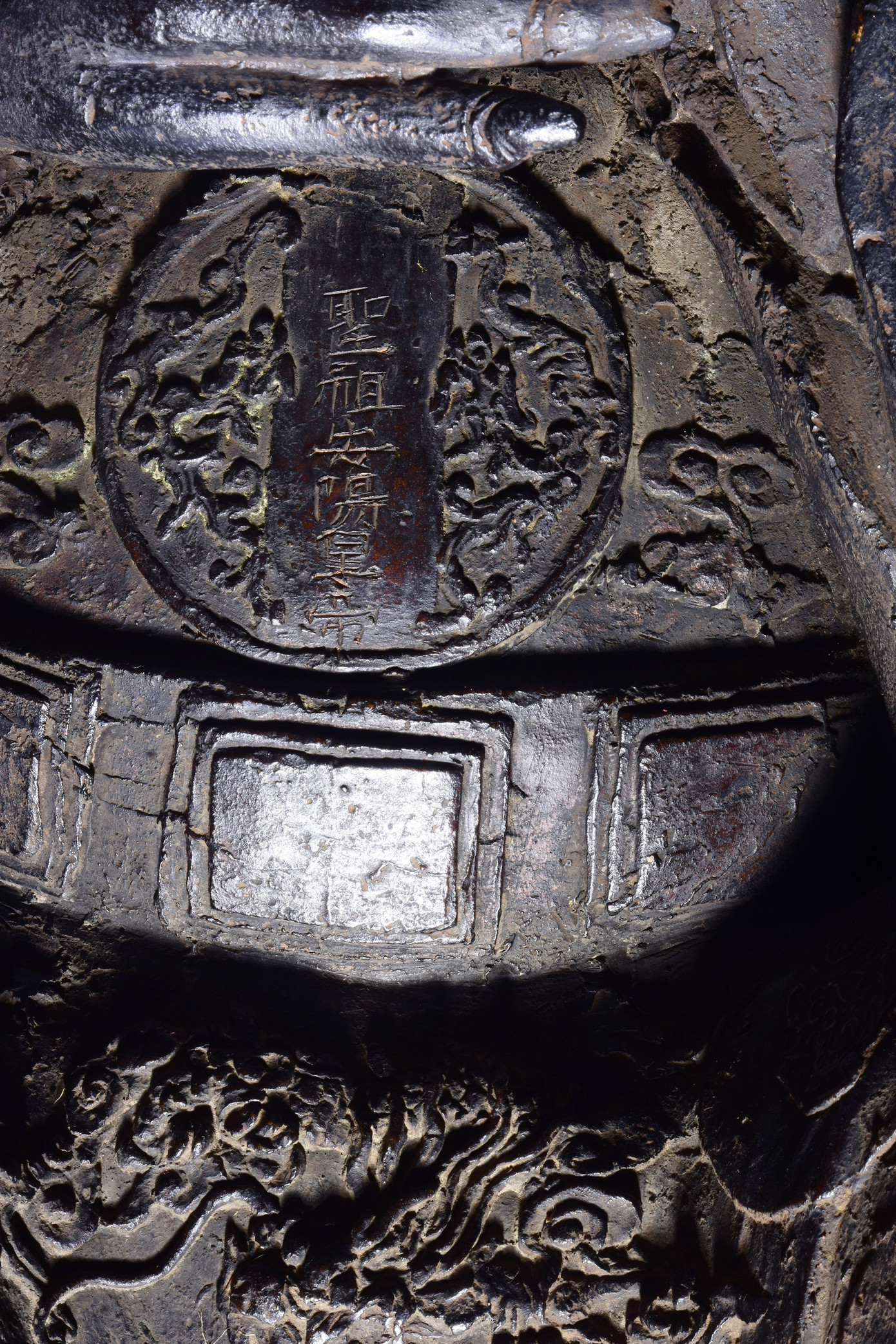 Các dòng chữ Hán được khắc và dát vàng: 聖祖安陽皇帝 "Thánh tổ An Dương Hoàng đế" (Thánh tổ Hoàng đế An Dương) ở vị trí hộ tâm tròn, mài nhẵn dưới bụng; 丁酉年五月十六日鑄 "Đinh Dậu niên, ngũ nguyệt thập lục nhật chú", tức đúc ngày 16 tháng 5 năm Đinh Dậu (1897), 銅像二百五十五斤 "Đồng tượng nhị bách ngũ thập ngũ cân" (nghĩa là: Tượng đồng nặng 255 cân) ở hai “lưỡi xén” sau lưng pho tượng.