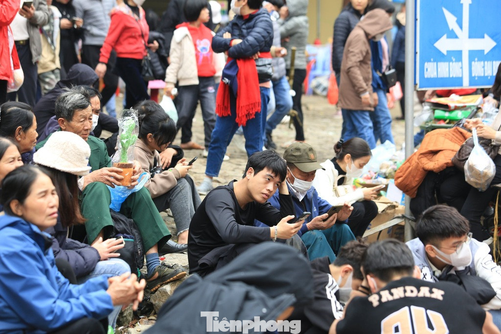 Du khách ngồi ở lối lên động Hương Tích vì mệt mỏi, không có chỗ nghỉ chân. Ảnh: TRỌNG TÀI.