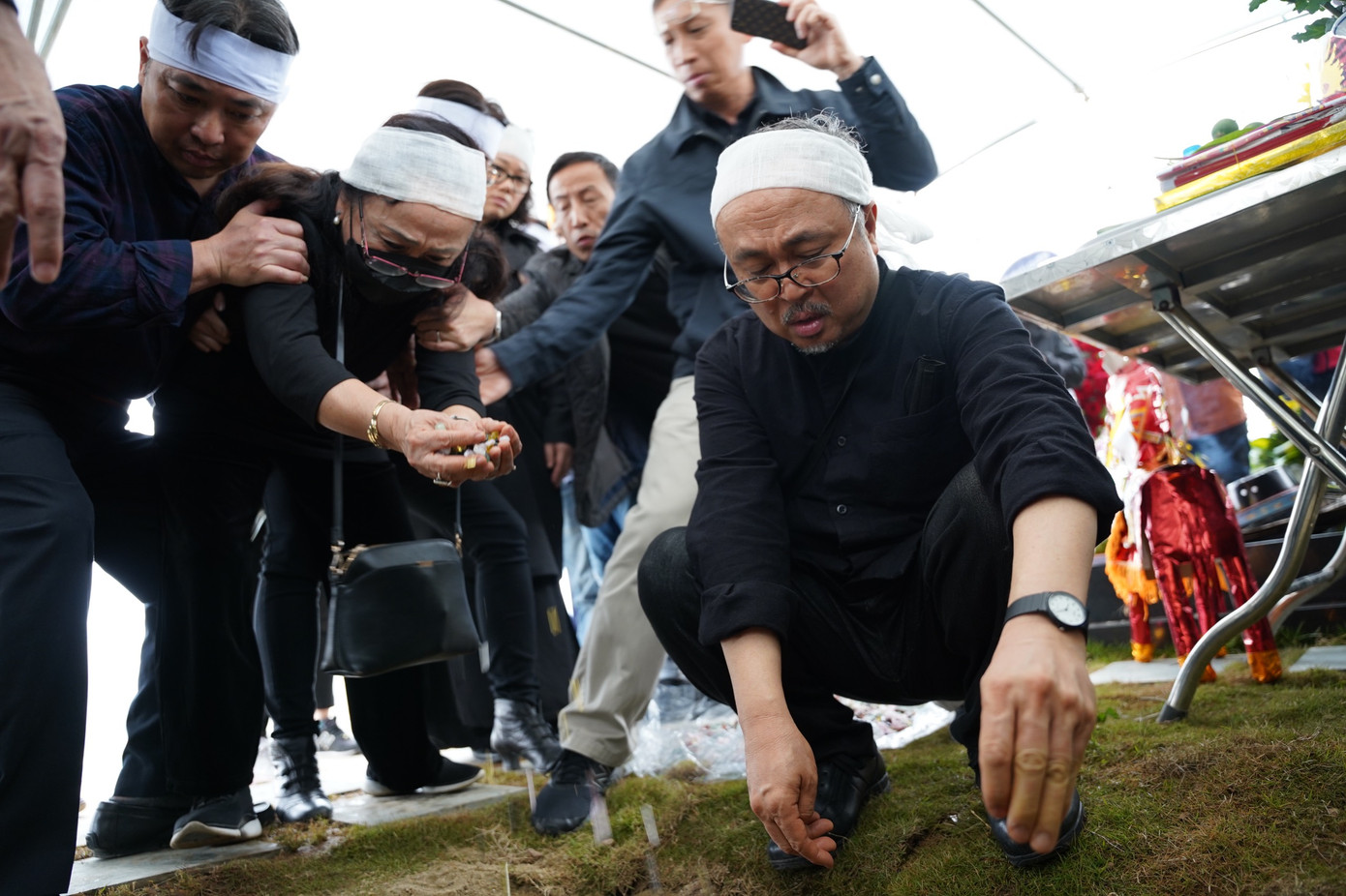 Trong phút giây tiễn biệt, NSND Đặng Thái Sơn - con trai của nghệ sĩ Thái Thị Liên và nhà thơ Đặng Đình Hưng - cùng gia đình rơi nước mắt. Ảnh: XUÂN QUỲNH.
