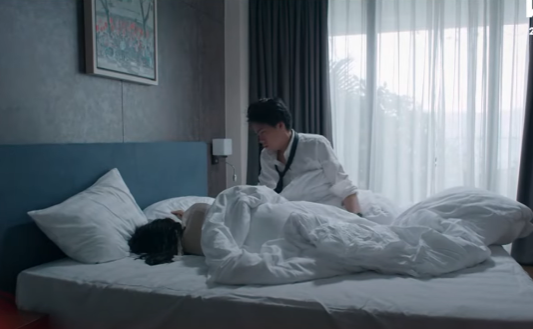 Phi (Thái Dũng) thức dậy với một cô gái lạ. Ảnh: CMH.