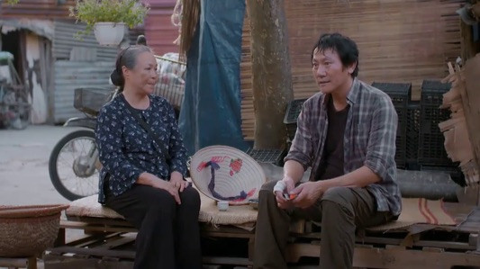 Bà Tình (NSƯT Thanh Quý) định nghỉ bán bánh rán, về phụ Luyến (Thanh Hương) mở sạp bán hoa quả. Ảnh: CMH.