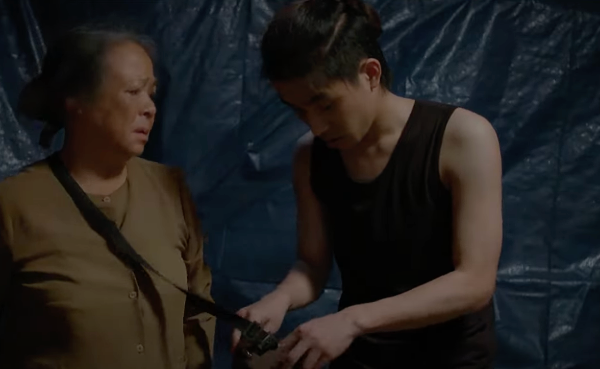 Bát (Tuấn Anh) lục túi bà Tình (NSƯT Thanh Quý) để lấy tiền. Ảnh: CMH.