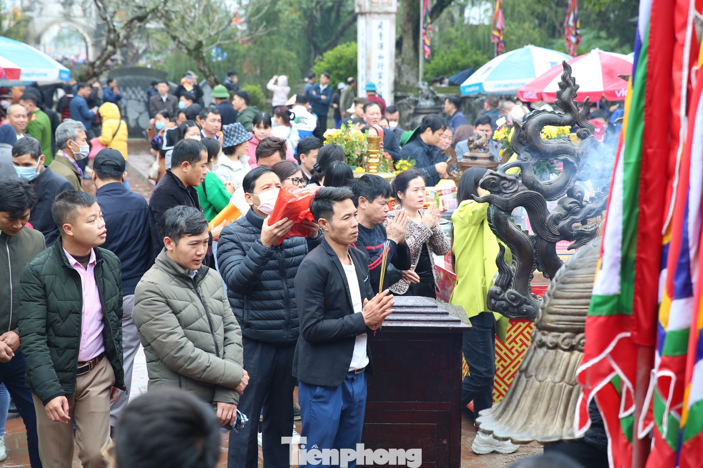 Từ 9h sáng ngày 5/2, sân đền Thiên Trường dần đông người hơn. Du khách đi lễ xong xếp hàng xin ấn. Ảnh: TRỌNG TÀI.