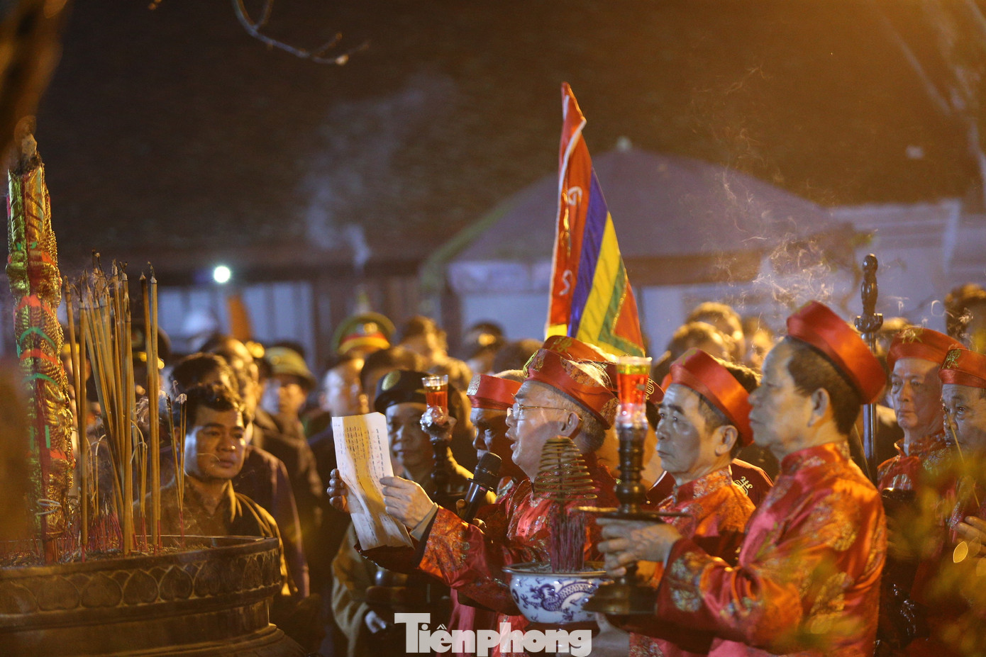 Nghi lễ Khai ấn có sự tham gia của 14 cụ cao niên trong họ Trần của làng Tức Mạc, phường Lộc Vượng. Bồi tế đặt giấy điệp trịnh trọng trước chủ tế. Khi chiêng trống vang lên, chủ tế nghiêm trang đóng ấn mực đỏ vào tập giấy điệp. Ảnh: TRỌNG TÀI.