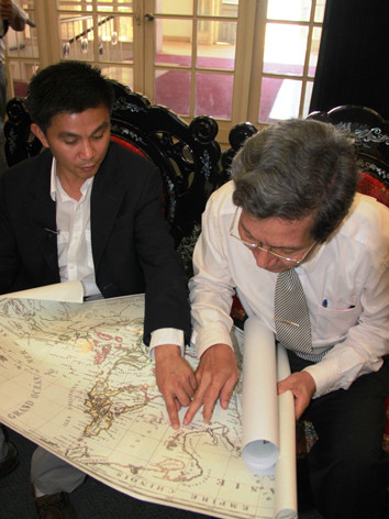 Anh Thắng (trái) và ông Ngữ thẩm định giá trị 2 bản đồ cổ Đông Ấn Độ và Đế chế Trung Hoa