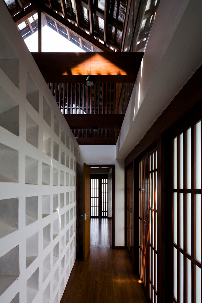 Mái nhà dốc bằng gỗ lợp ngói gốm với cửa sổ thoát khí nâng cao trên đỉnh.