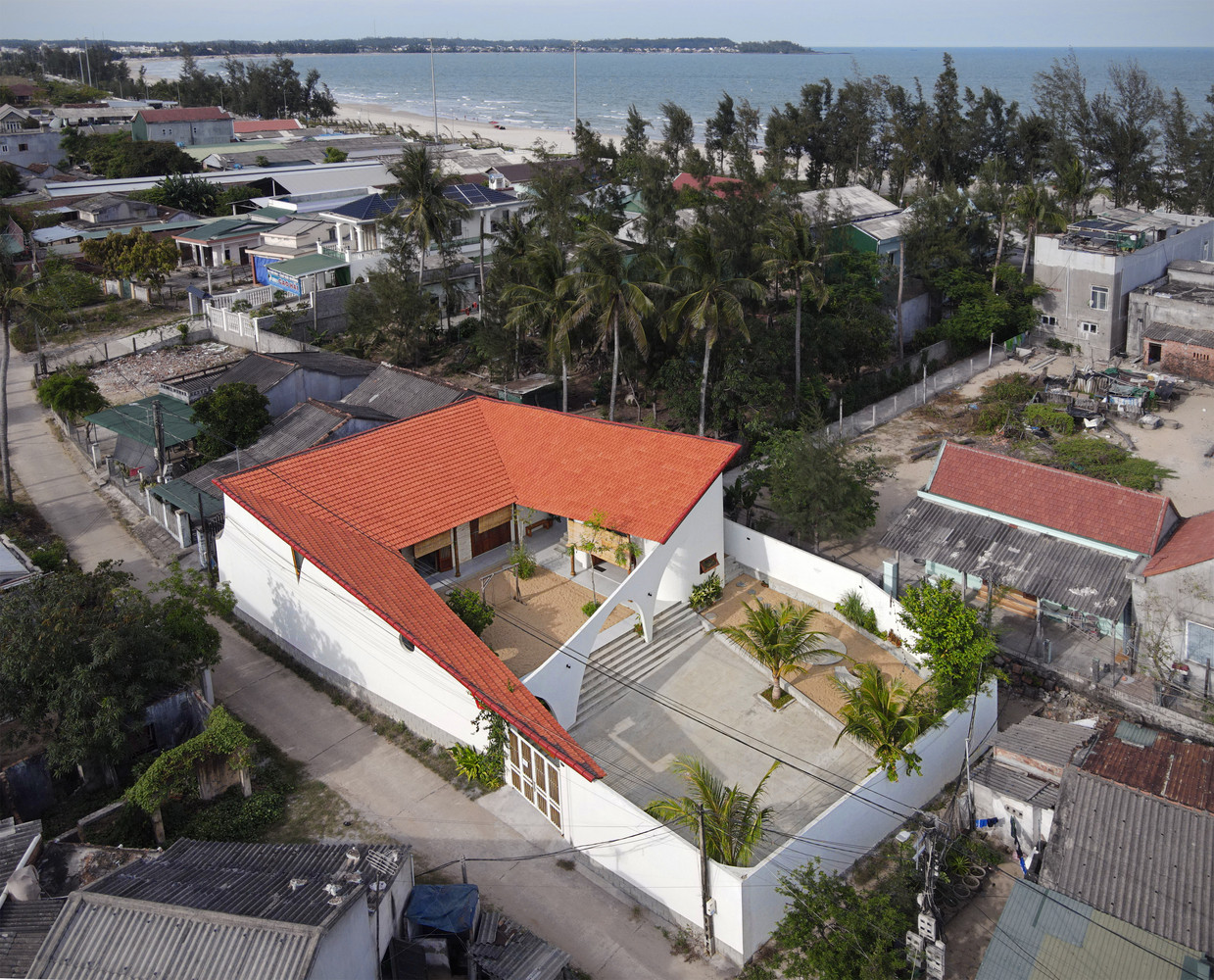 Do ngôi nhà nằm trong một làng chài nhỏ, bao quanh là cát biển nên ngôi nhà sử dụng màu ngói đỏ để không phá vỡ cảnh quan xung quanh. Để phù hợp kiến trúc nhiệt đới, mái ngói được làm dốc để thoát nước mưa nhanh. Do ngôi nhà nằm trong một làng chài nhỏ, bao quanh là cát biển nên ngôi nhà sử dụng màu ngói đỏ để không phá vỡ cảnh quan xung quanh. Để phù hợp kiến trúc nhiệt đới, mái ngói được làm dốc để thoát nước mưa nhanh.