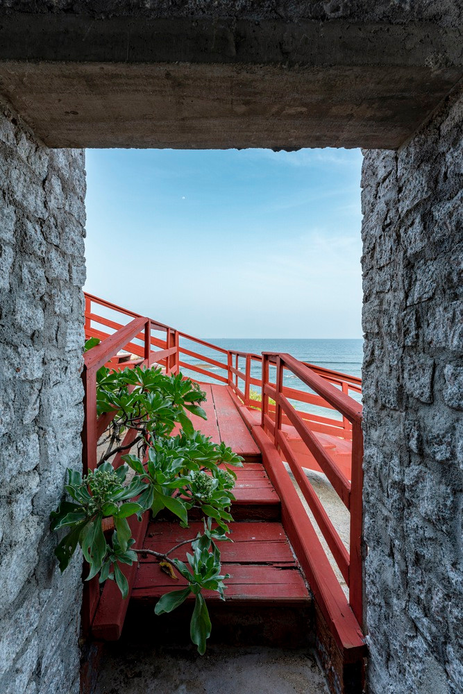 Vật liệu xây dựng là đá granit thừa, có nguồn gốc từ mỏ cách đó 30 km với giá cả phải chăng, mái nhà được làm từ tre và nhựa.