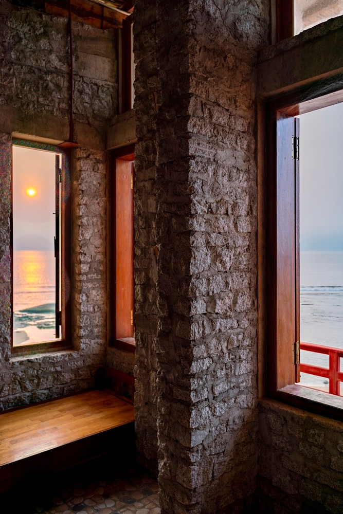 Vật liệu xây dựng là đá granit thừa, có nguồn gốc từ mỏ cách đó 30 km với giá cả phải chăng, mái nhà được làm từ tre và nhựa.