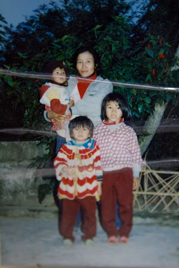 Hoàng Thùy trên tay mẹ, cùng 2 chị gái của cô