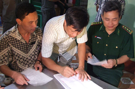 Đại tá Bùi Văn Điển (giữa) cùng đại diện lực lượng Biên phòng ký biên bản bàn giao đối tượng Lê Văn Luyện.