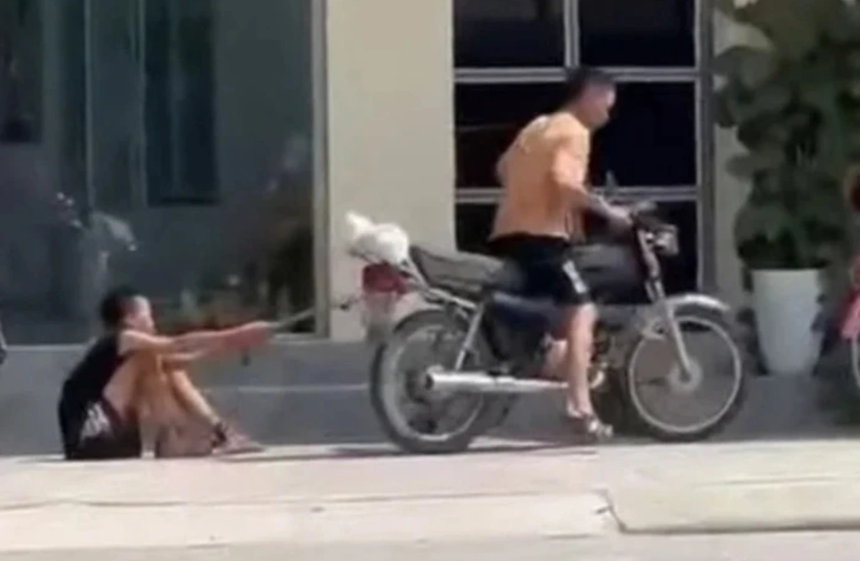 Hình ảnh bé trai bị bố xích chân kéo lê trên đường Hình ảnh bé trai bị bố xích chân kéo lê trên đường