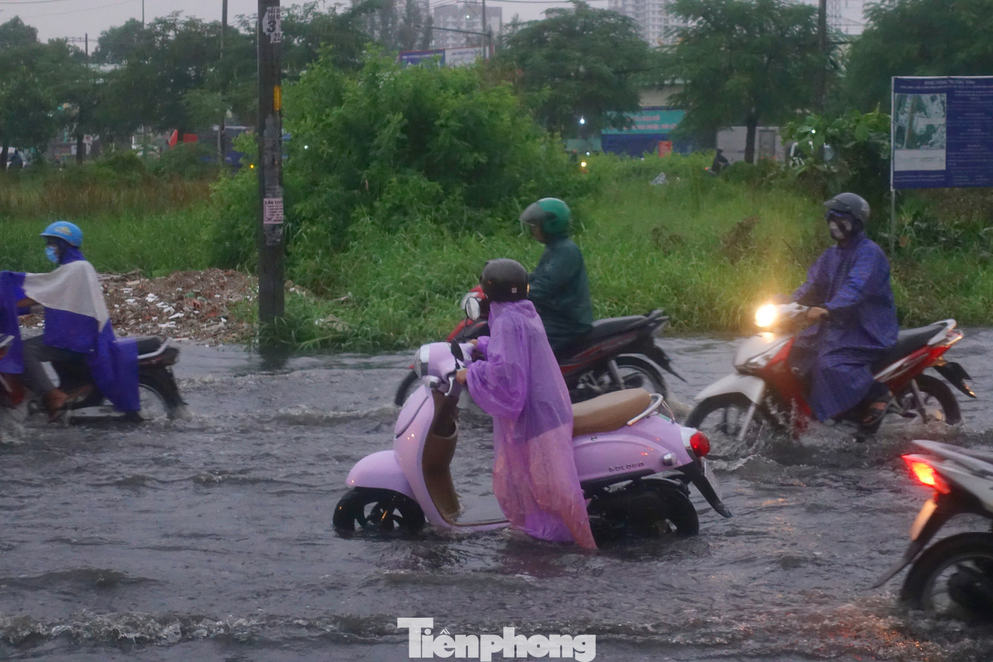 Người dân lội bì bõm đưa phương tiện thoát khỏi điểm ngập.