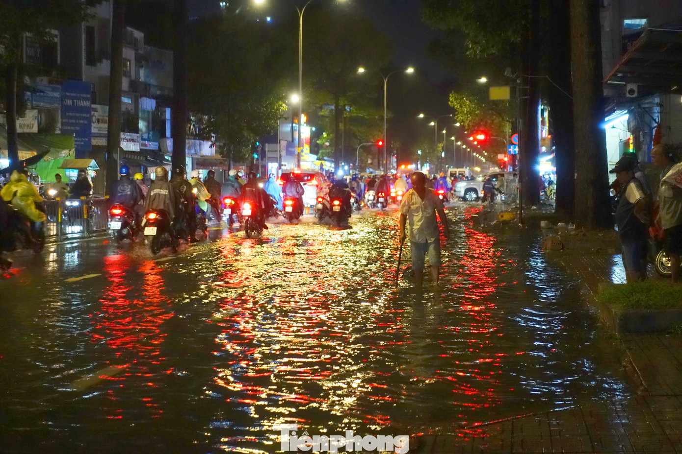 Người dân túc trực ở miệng cống trên đường 3 tháng 2 để vớt rác, khơi thông dòng chảy.