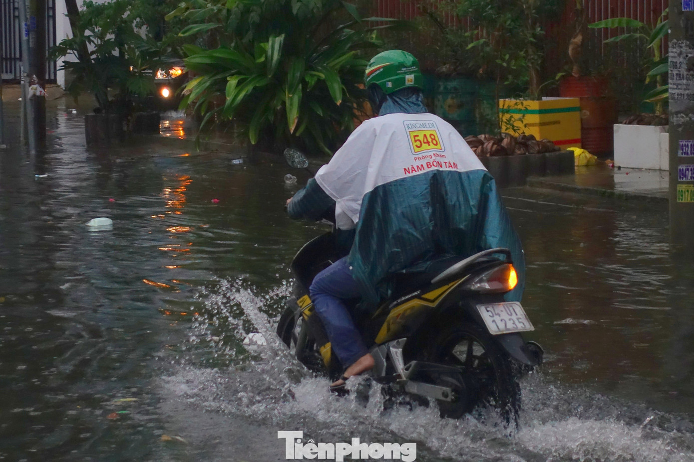 Nước ngập nửa bánh xe khiến giao thông qua khu vực gặp nhiều khó khăn.