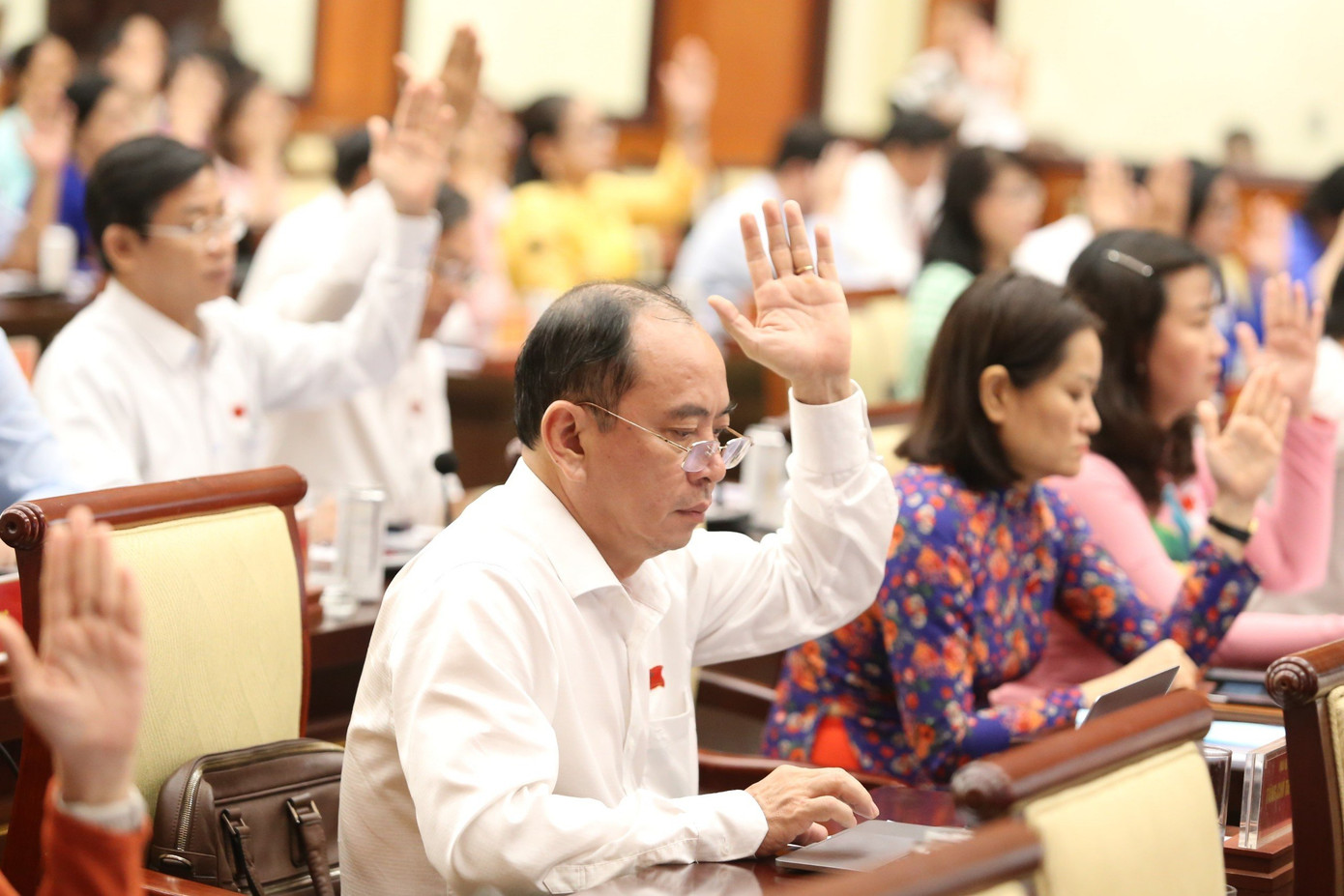 Đại biểu HĐND TPHCM biểu quyết thống nhất mức thu phí sử dụng tạm thời lòng đường, hè phố trên địa bàn thành phố. Ảnh: Ngô Tùng