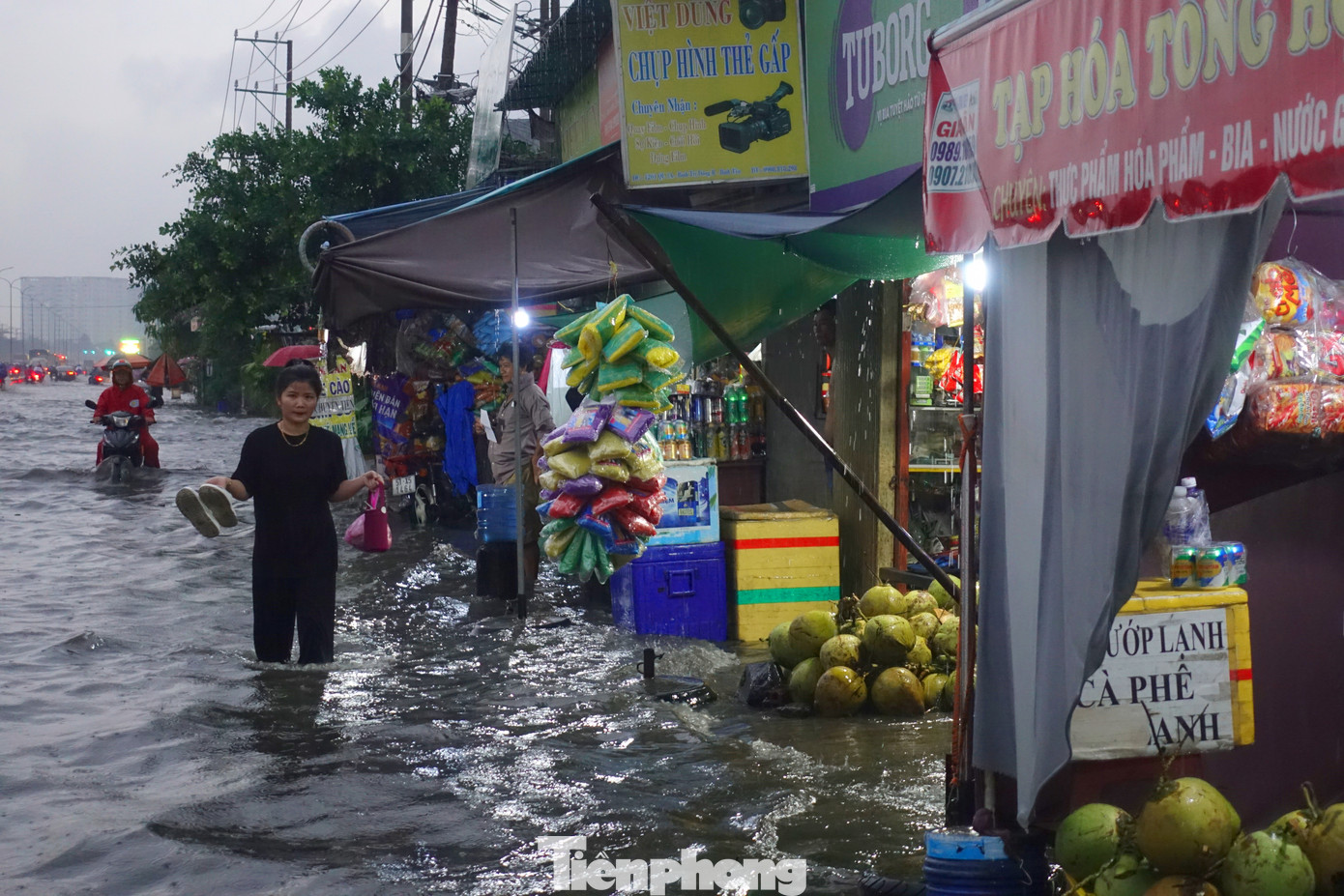 Nước ngập sâu, người dân phải xách dép lội bì bõm trên quốc lộ 1.