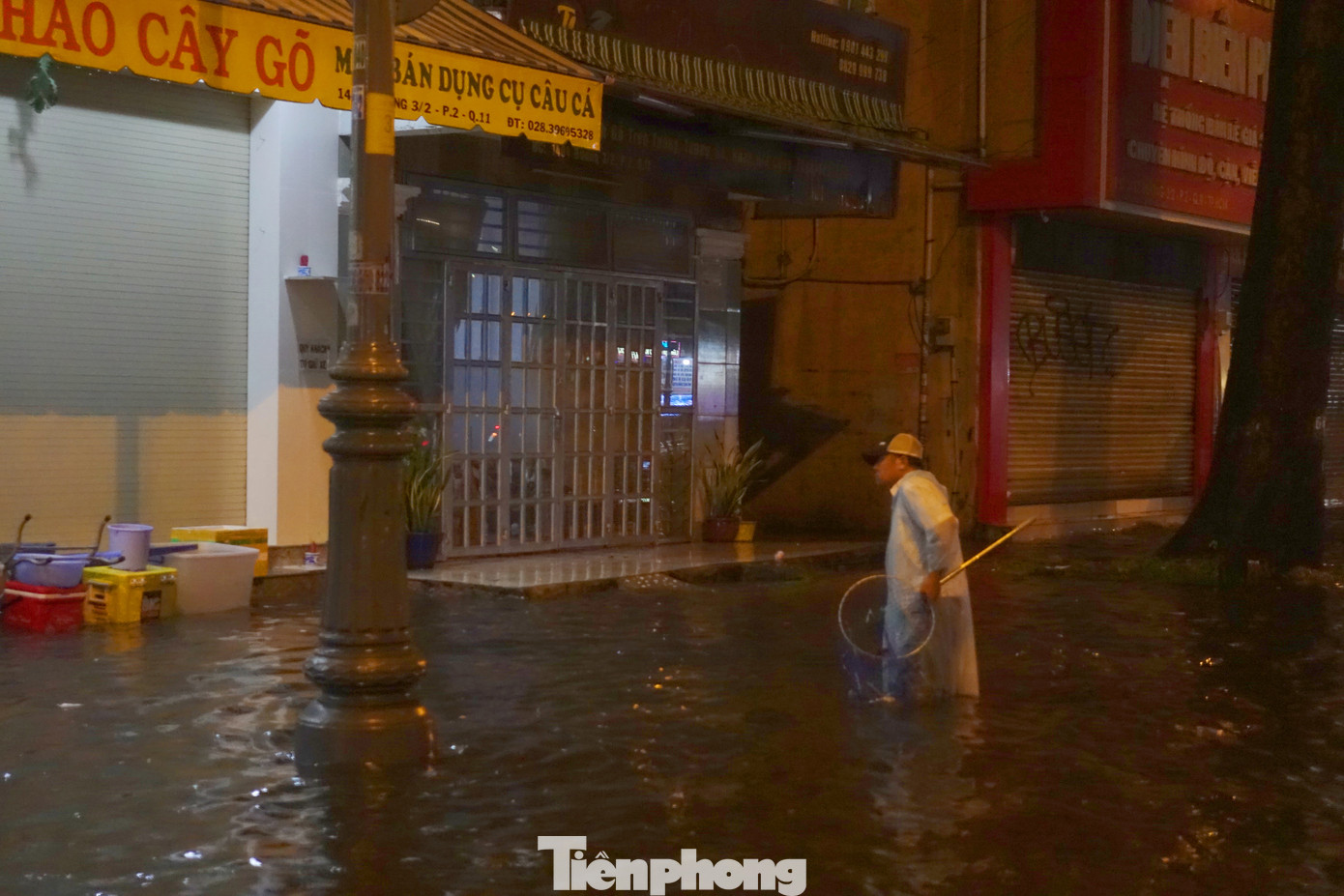 Người dân mang vợt để vớt rác ở các miệng cống.