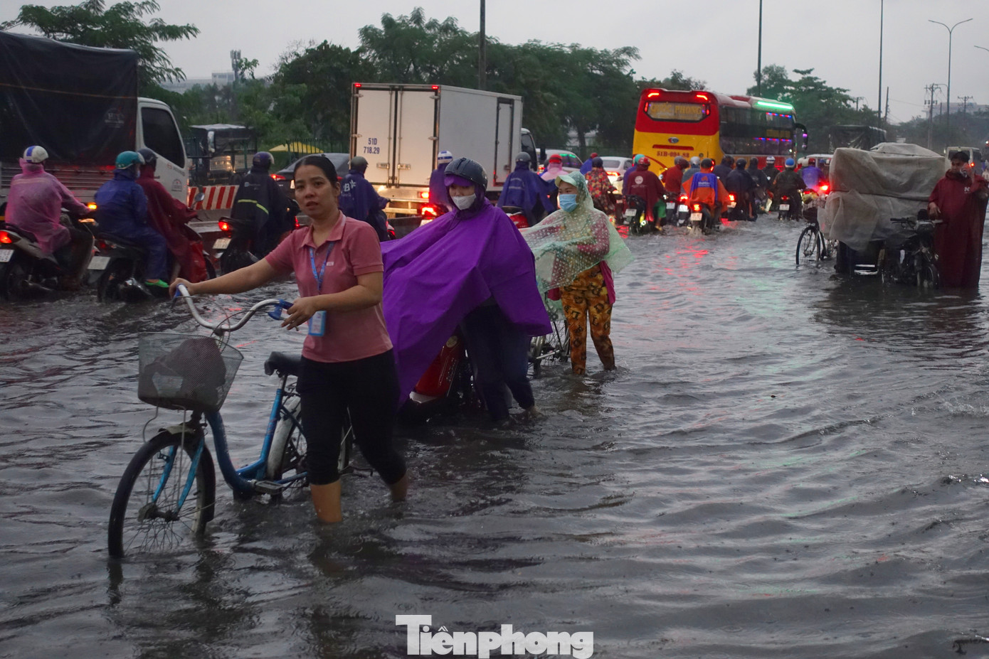Làn đường hỗn hợp của quốc lộ 1 (đoạn qua phường Bình Trị Đông B, quận Bình Tân) bị ngập sâu, công nhân tan ca phải bì bõm lội nước về nhà.
